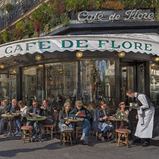 Des gens qui déjeunent et boivent du café, du vin et de la bière sur la terrasse du Café de Flore.