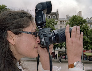 A photography student taking pictures in place Joachim-du-Bellay with a Nikon DSLR.
