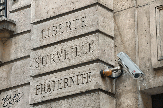 A surveillance camera on the fa&ccedil;ade of the Cr&eacute;dit Municipal, next to the motto of the French Republique: &laquo;Libert&eacute;, &Eacute;galit&eacute;, Fraternit&eacute;&raquo;; &ldquo;Liberty, Equality, Fraternity&rdquo;. The slogan is engraved on on both sides of this entrance at 16, rue des Blancs Manteaux, to avoid such an unfortunate juxtaposition, the camera would have to have been mounted at the top center of the doorway.