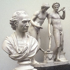 Une femme en train de regarder des sculptures dans le musée Victoria et Albert.