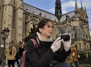 A young woman photographing teenagers doing on roller blades.