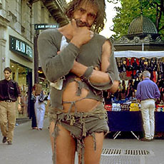 A homeless man dressed in rags on boulevard Saint-Michel.