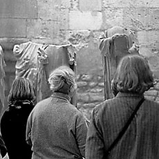 Des visiteurs au musée du Moyen Âge regardant des statues décapitées.