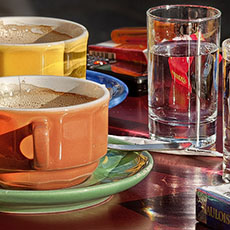 Deux tasses de café et deux verres d’eau sur une table d’un café parisien.