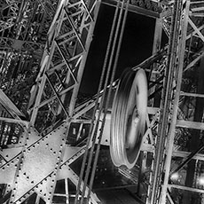 Des poutres en fer, poulies et câbles à l’intérieur de la tour Eiffel.