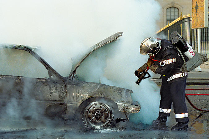 Clouds of steam and smoke rising from a car that had entirely burned in Paris.