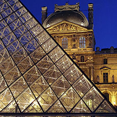 La Grande Pyramide du Louvre avec le pavillon Denon en arrière plan le soir.