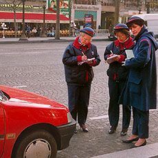 Three meter maids writing parking tickets for one car on the Champs-Élysées.