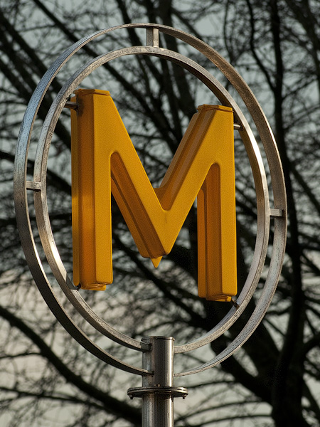 A Patis Métro sign from the 1970s made of yellow plastic and stainless steel.