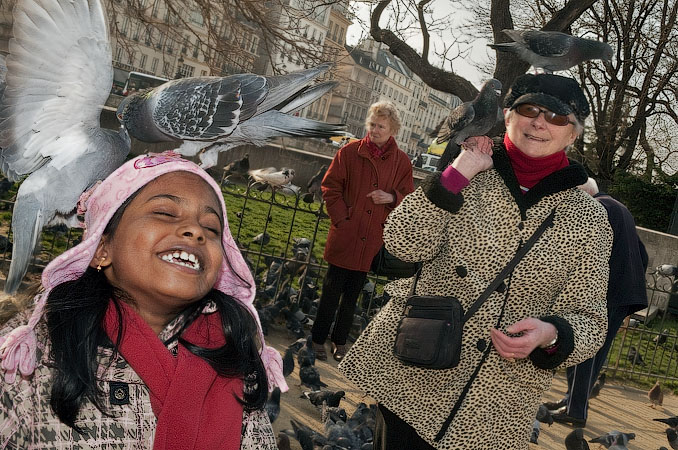 People feeding pigeons in front of Notre-Dame Cathedral.