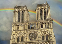 A rainbow passing behind the main façade of cathédrale Notre-Dame.