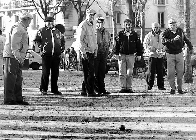 Seven men men playing pétanque in place de la Nation.