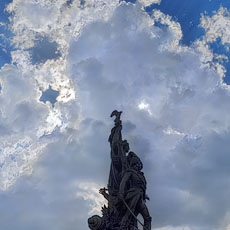 Le soleil et des nuages derrière la sculpture dans la place de Clichy.