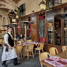 Un serveur rentre à l’intérieur du restaurant Ma Bourgogne dans la place des Vosges.