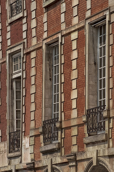 Des cadres de fenêtre en pierre tordus dans la place des Vosges.