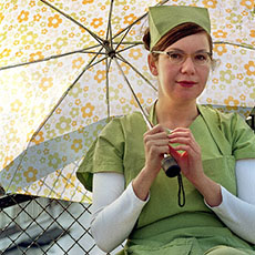 Nili Blumberg dressed as Nurse Clara, scratching backs on pont des Arts.