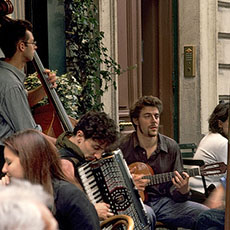Three musicians playing in front of le Bistrot des Oies on rue Marie-et-Louise.
