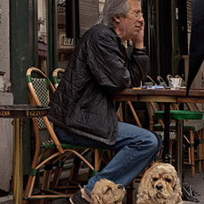 A man with two dogs on in front of a restaurant on rue Rambuteau.