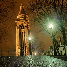 Le beffroi du Sacré-Cœur et des escaliers de la rue Lamarck le soir.