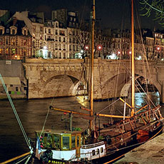 Des bateaux arrimés à côté de l’île de la Cité en amont du pont Neuf le soir.