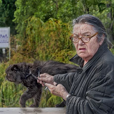 An old woman walking with her black cat on pont Louis-Philippe.