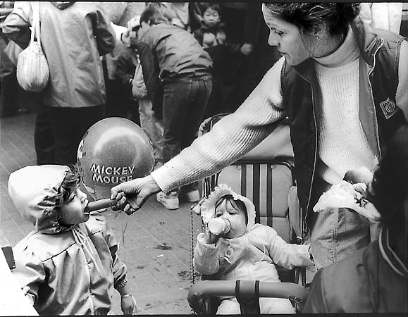 A woman feeding her daughter a hotdog in Downtown Crossing, Boston.