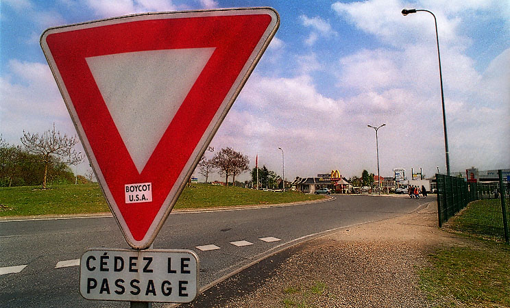 A yield sign with a sticker reading “Boycot USA” near Maincy, France.