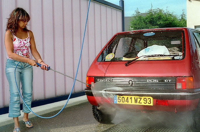Une femme en train de laver sa voiture à Cabourg.