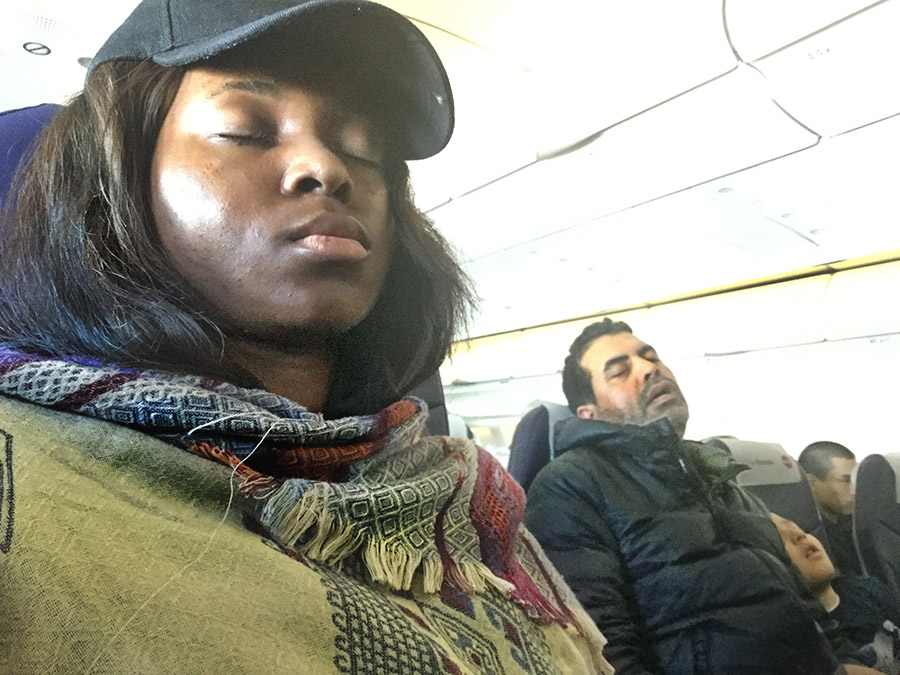 Three people sleeping on a airplane over the Atlantic Ocean.