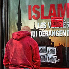 A (willfully) homeless man urinating on a newstand in front of a poster with the headline, «Islam, les vérités qui dérangent». (Disturbing truths about Islam).