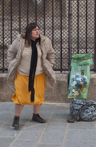A homeless woman preparing to take down her skirt in order to defecate next to Notre-Dame.