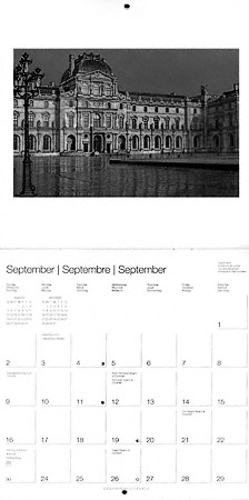 A black and white photograph of the Louvre museum’s Cour Carrée.